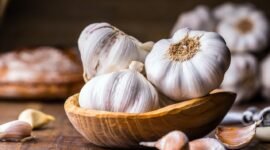 Garlic Cloves and Bulb in vintage wooden bowl.