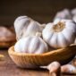Garlic Cloves and Bulb in vintage wooden bowl.