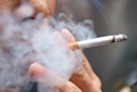 Smoking a cigarette with smoke around and a blurred background