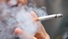Smoking a cigarette with smoke around and a blurred background